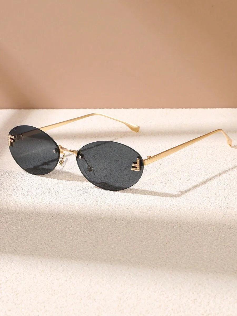 CALORA_ Elegante Ovale Zonnebril met Gouden Accenten en Subtiele Steentjes
