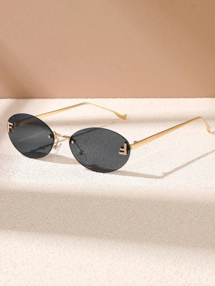 CALORA_ Elegante Ovale Zonnebril met Gouden Accenten en Subtiele Steentjes